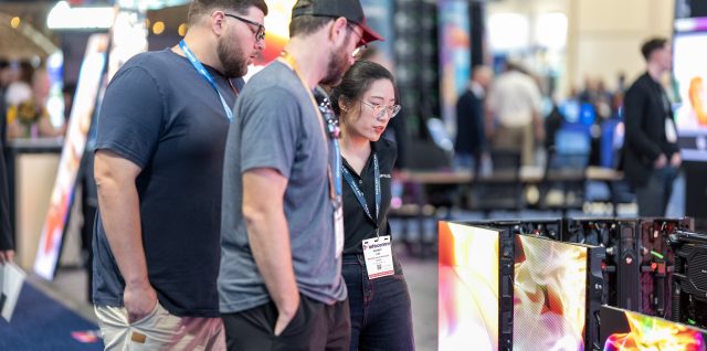 Visitors looking closely at fine-pitch LED screens on the INFiLED booth at InfoComm 2025 in Orlando